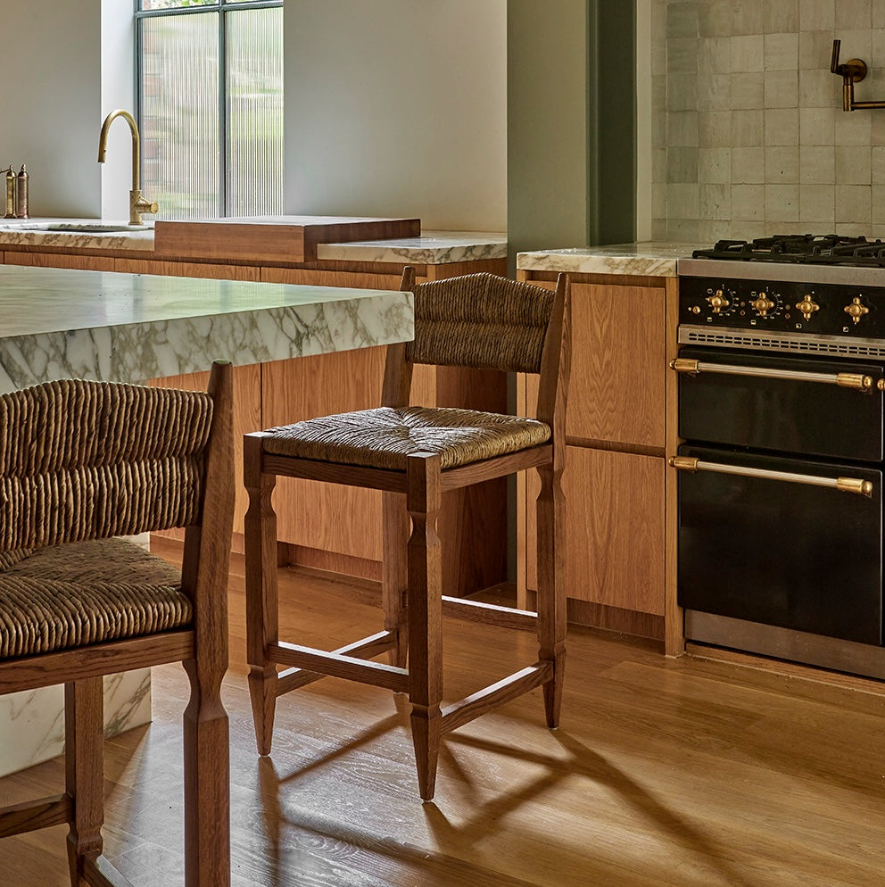 timber and rush weave counter stools in marble kitchen